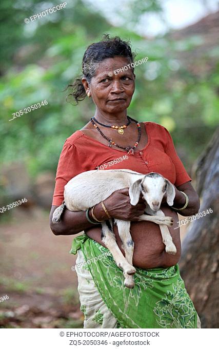 Katkari tribal woman holding a young goat in her hand, Maharashtra, India. The Katkari are an Indian Hindu community mostly belonging to the state of...