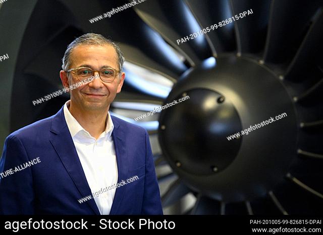 02 October 2020, Brandenburg, Ludwigsfelde: Andre Sinanian, President and CEO of MTU Maintenance Berlin Brandenburg, stands next to a model of a geared turbofan...
