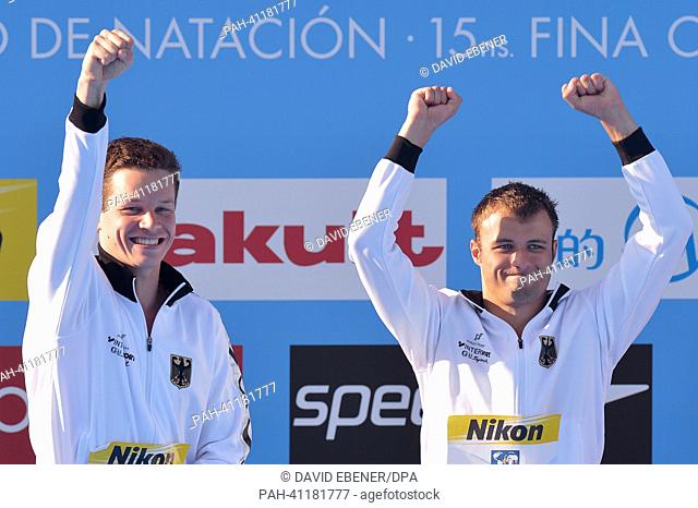 Gold medalists Patrick Hausding (L) and Sascha Klein of Germany celebrate on the podium after the men's 10m Synchro Platform diving final of the 15th FINA...