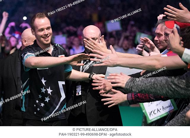 21 March 2019, Berlin: The German Dartprofi Max Hopp (l) marching into the Premier League in the sold out Arena at the Ostbahnhof