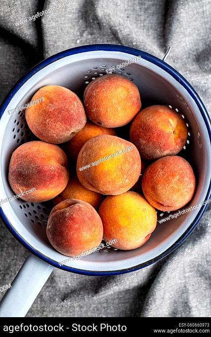 Fresh ripe bio peaches in colander. Top view