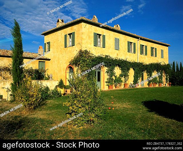 Exterior of a yellow painted Italian villa, window with shutters