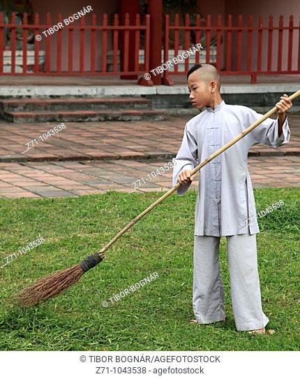 Vietnam, Hue, Thien Mu Pagoda, young monk gardening