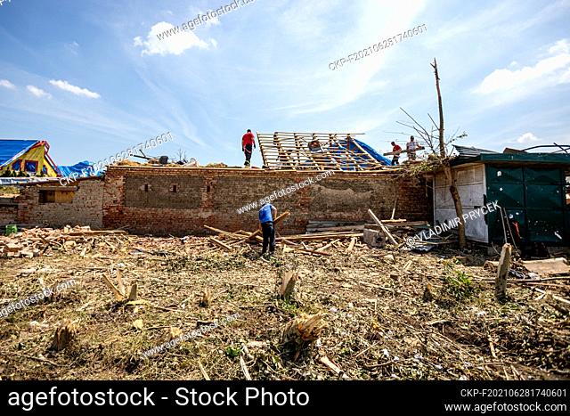 People clean debris after a tornado storm which passed through the Hrusky village in the Breclav district, South Moravia, Czech Republic, June 27, 2021