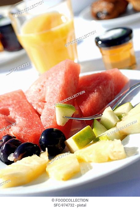 Plate of fruit, fruit juice and honey for breakfast