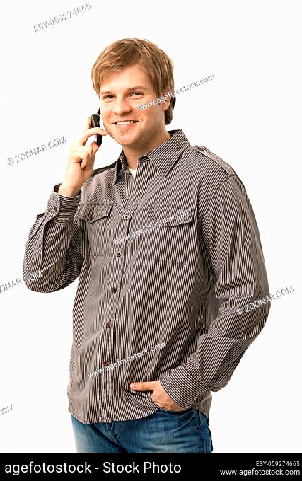 Casual young man talking on mobile phone, smiling. Isolated on white