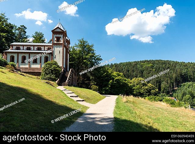 Mespelbrunn, Bavaria - Germany:The chape in the green hills with a walking path on a hot summer day