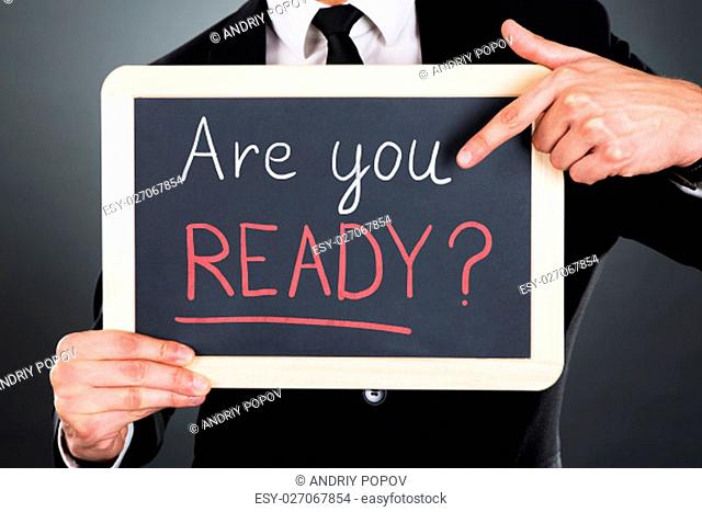 Midsection of young businessman pointing Webinar sign drawn on slate over gray background