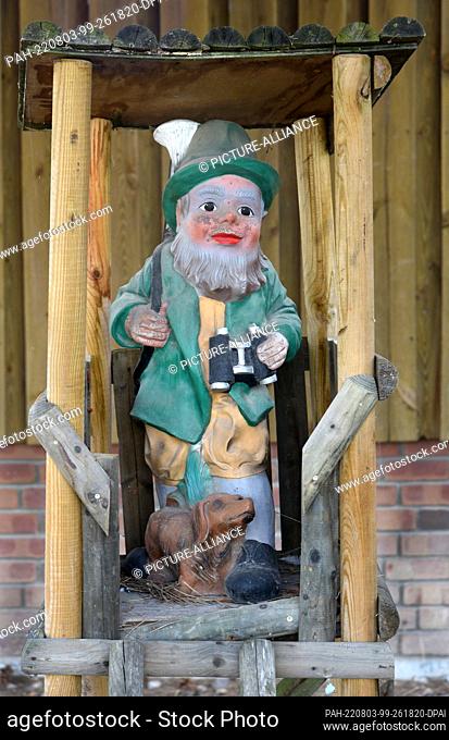 02 August 2022, Saxony, Doberstau B. Delitzsch: A wooden Santa Claus stands at the entrance to Ulrich Haberland's Sächsische Christbaum GbR ""Fasanerie"" in...