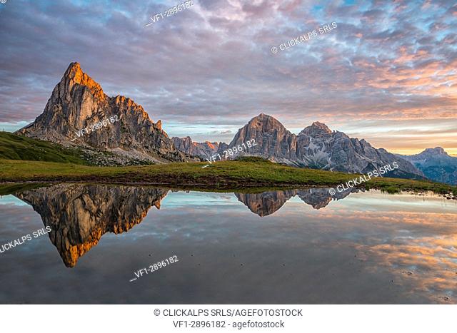 Gusela mountain at sunrise reflected in small lake, Giau Pass, Dolomites, Veneto, Italy