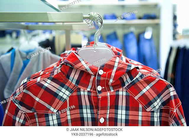 Close-up of blouse, shirt on hanger. Rack, colorful clothing. Fashion in retail store, shop