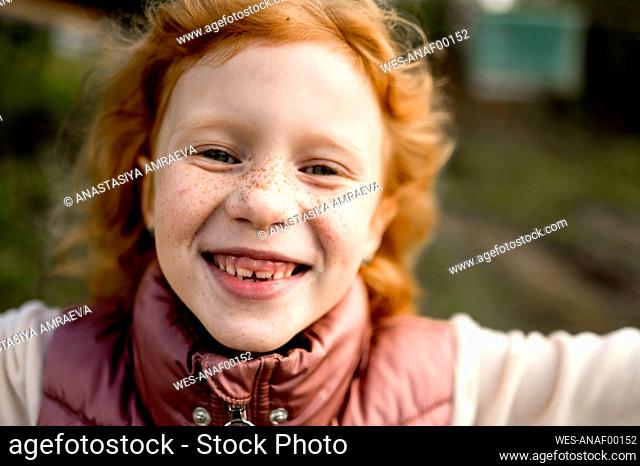 Cute happy girl with freckles on face