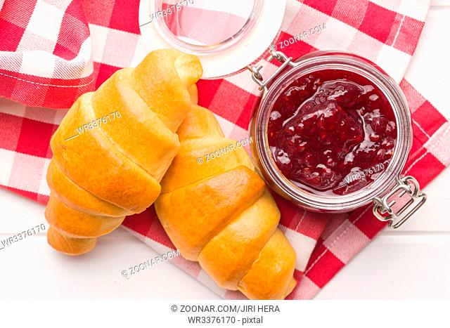 Sweet croissants and jam on checkered napkin