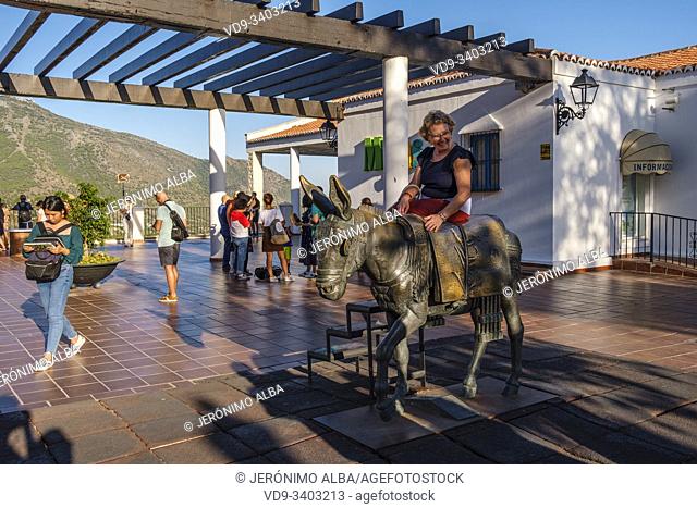Tourists taking a picture in the typical donkey taxi, white village of Mijas Pueblo. Malaga province, Costal del Sol. Andalusia, Southern Spain
