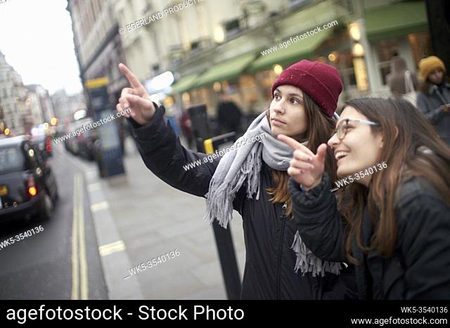 two women pointing up. London, England