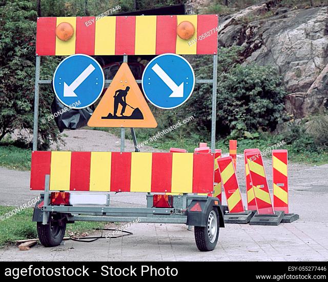 Fences and signs of carrying out repair work on road. Sign road works - Workers ahead