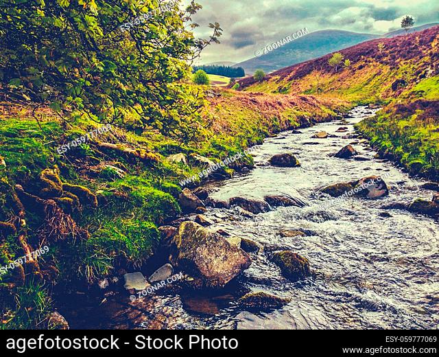 Retro Style Image Of A Fast Flowing River Through Wild Countryside In The Borders Of Scotland, UK