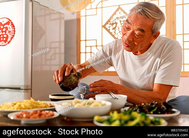 Old people sitting at home eating drinking