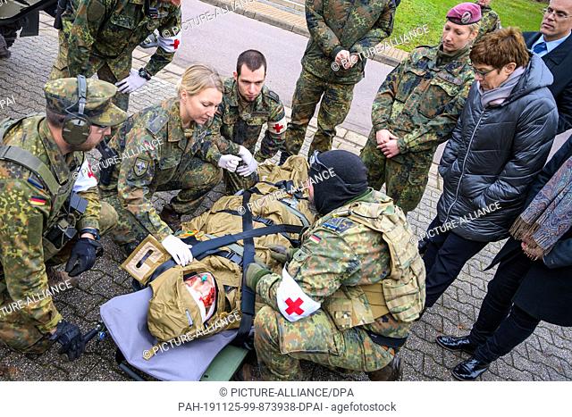 25 November 2019, Saarland, Saarlouis: Paramedics of the Paratrooper Regiment 26 demonstrate the care of an injured soldier to Defence Minister Annegret...