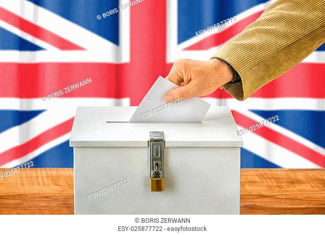 man putting ballot in ballot box - uk