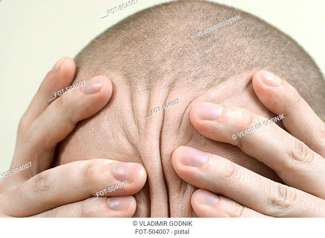 Detail of a man rubbing his head