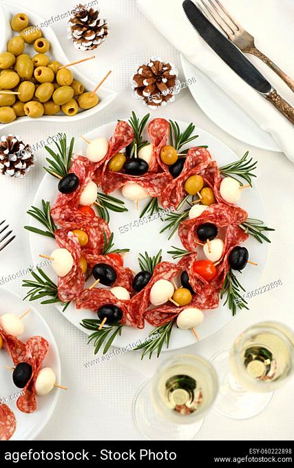 Christmas wreath - antipasto. Salami canapes with olives, baby mozzarella