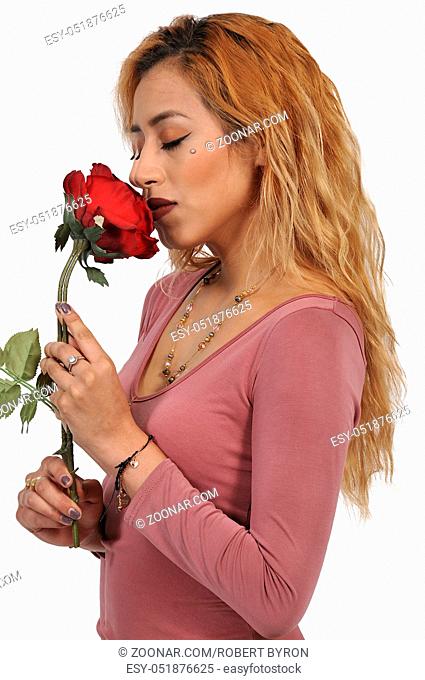 Beautiful woman smelling a fresh cut rose