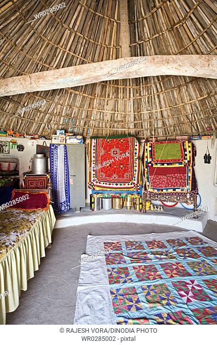 Interior of bhunga circular house with household utilities placed at circular walls , Kutch , Gujarat , India