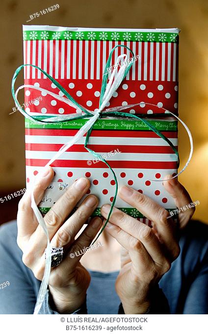 Christmas Present in the hands covering the face