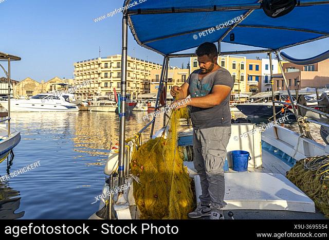 Fischer mit seinem Netz auf enem Boot im Hafen von Chania, Kreta, Griechenland, Europa | fisherman with his net on a a boat at the harbour in Chania, Crete