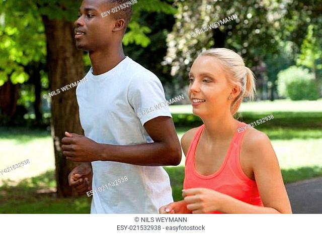 zwei sportliche junge jogger laufend im park im sommer