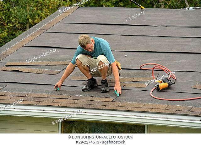 Re-roofing the garage roof. Using an automatic shingle nailer, Greater Sudbury (Lively), Ontario, Canada