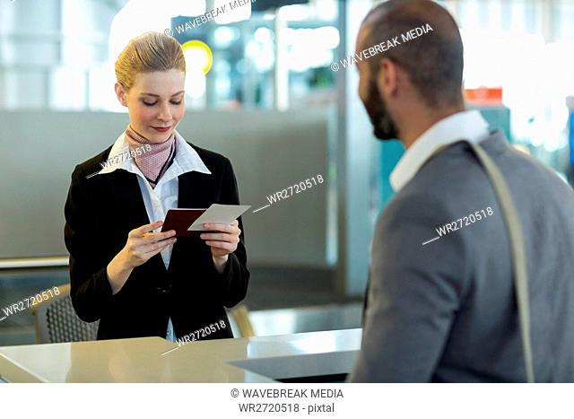 Commuter standing at counter while attendant checking his passport
