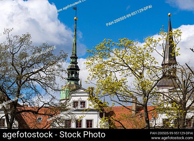 14 April 2020, Brandenburg, Doberlug-Kirchhain: The towers of the city castle above the roofs of the city. The Renaissance castle has seen several owners and...