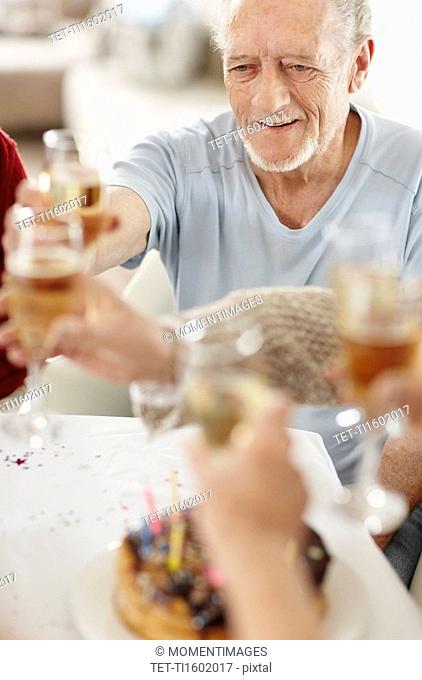 Senior man toasting with a glass of champagne
