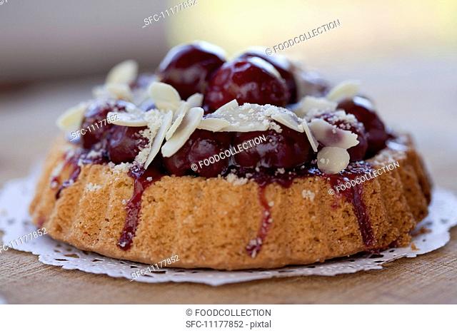 Individual cherry-topped cake with sliced almonds