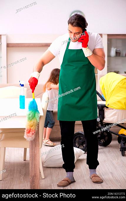 Young contractor cleaning the house with his small daughter