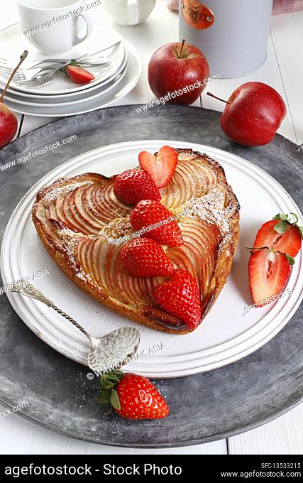 Heart-shaped apple cake decorated with strawberry slices