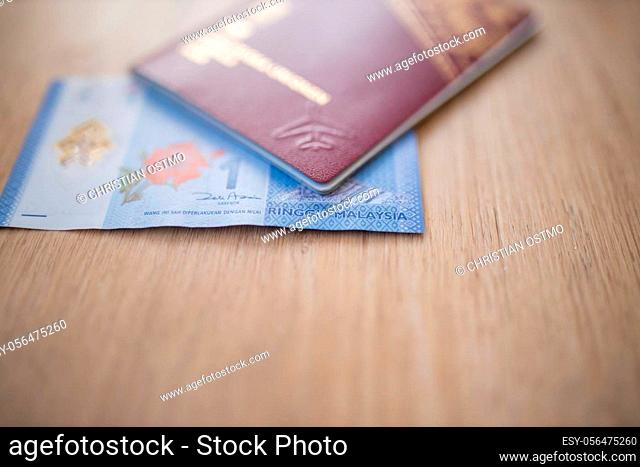 Picture of a Sweden Passport covering part of a blurry One Malaysian Ringgit Note