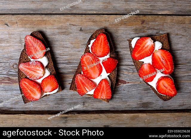 Healthy food. sandwiches with cream and strawberries on a wooden background
