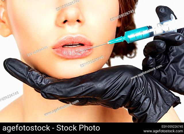 beautiful young woman getting beauty injection. studio shot isolated on white background. copy space