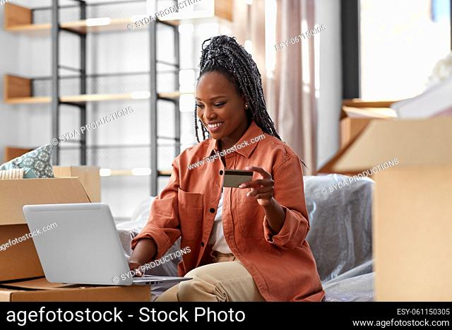 woman with laptop and credit card at new home