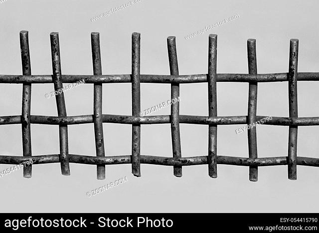 black and white photo rusty metal fence on a grey background