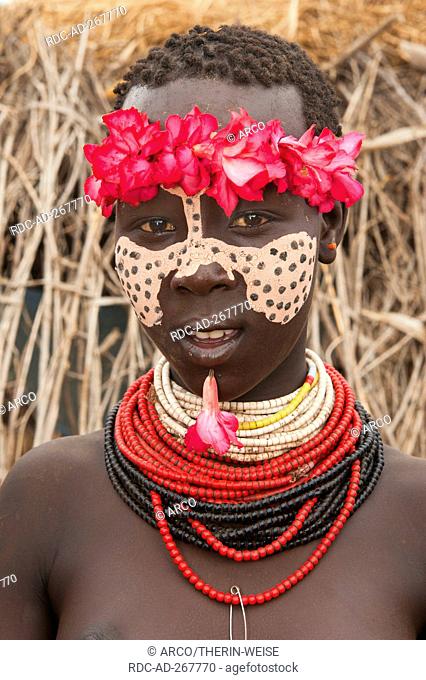 Karo girl with floral headband, facial paintings, colorful necklaces and lip piercing, Omo river valley, Southern Ethiopia