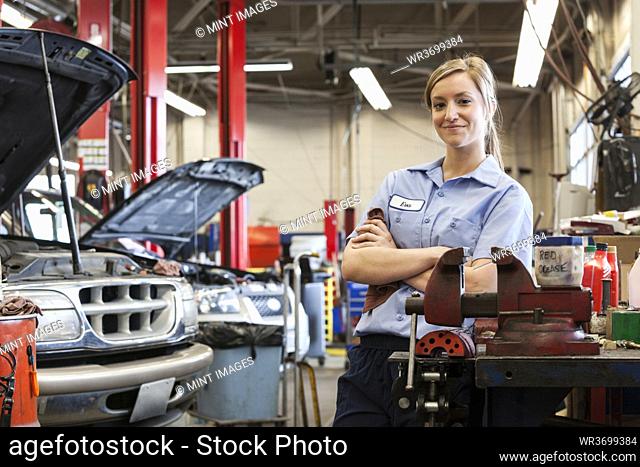 Portrait of young female Caucasian mechanic in auto repair shop