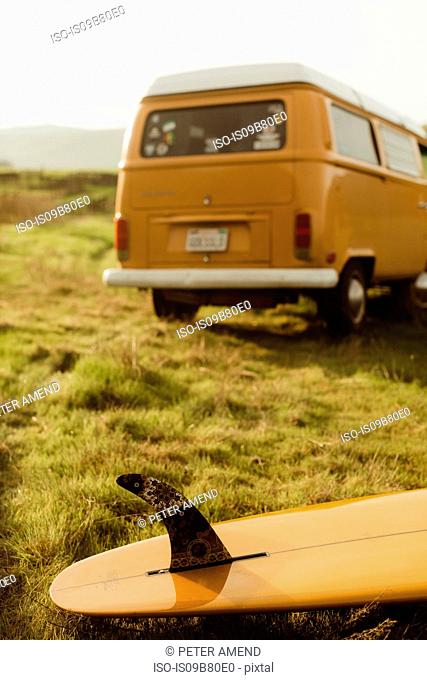 Yellow surfboard and vintage recreational van on roadside, Exeter, California, USA
