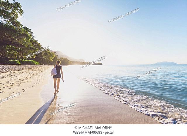Seychelles, Mahe, Beau Vallon Beach, woman walking on the beach at sunset