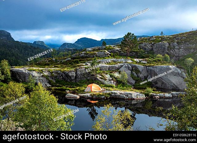 Tourist tent on the shore of a lake in the mountains. Beautiful Nature Norway natural landscape