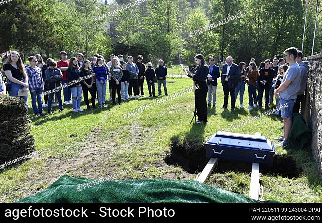 11 May 2022, North Rhine-Westphalia, Schleiden: Pupils of the Johannes-Sturmius-Gymnasium say goodbye to the coffin with the bones of a school skeleton at the...