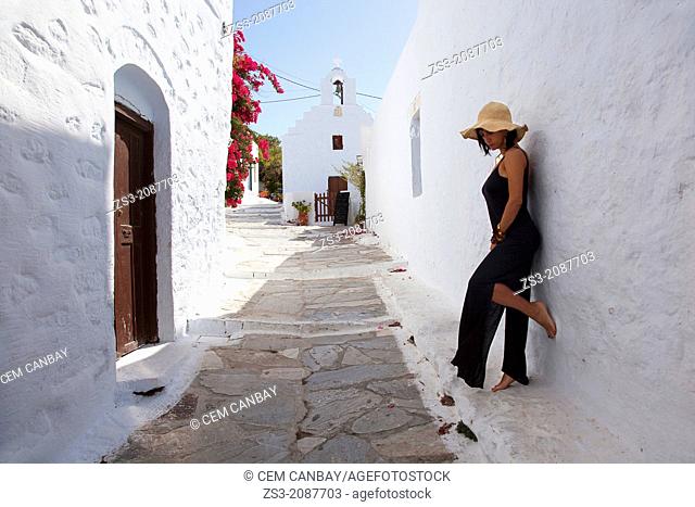Woman posing in front of a wall, Amorgos, Cyclades Islands, Greek Islands, Greece, Europe